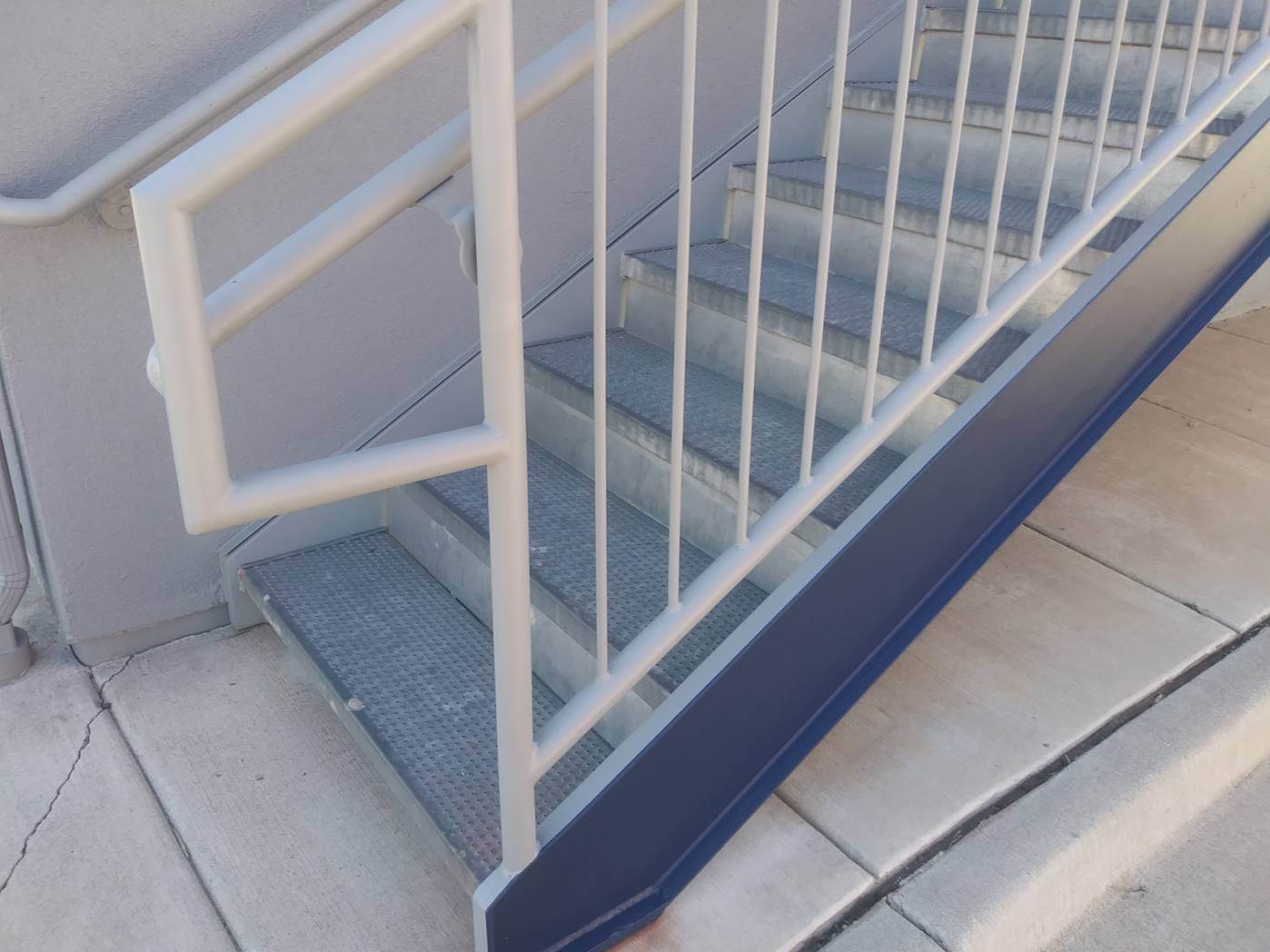 Exterior steel stairs and handrails after a direct to metal coating, with navy stringers and white railings