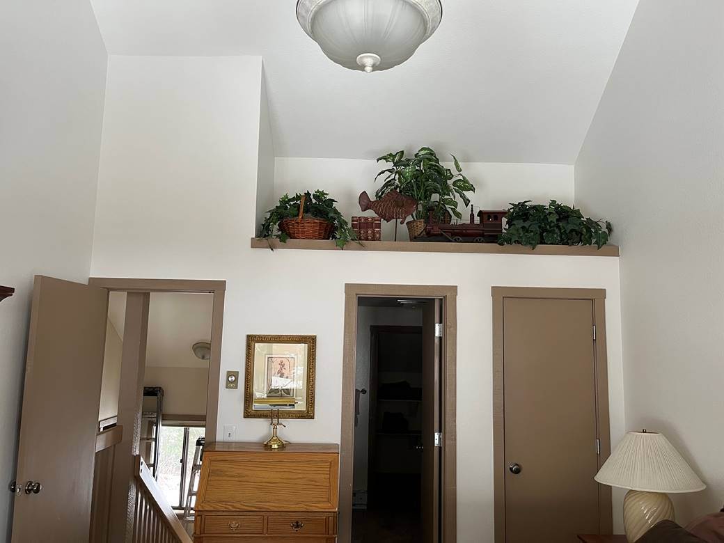 Vaulted two-story entry after interior painting, walls finished in a clean off white and cut sharp against the ceiling and door casings